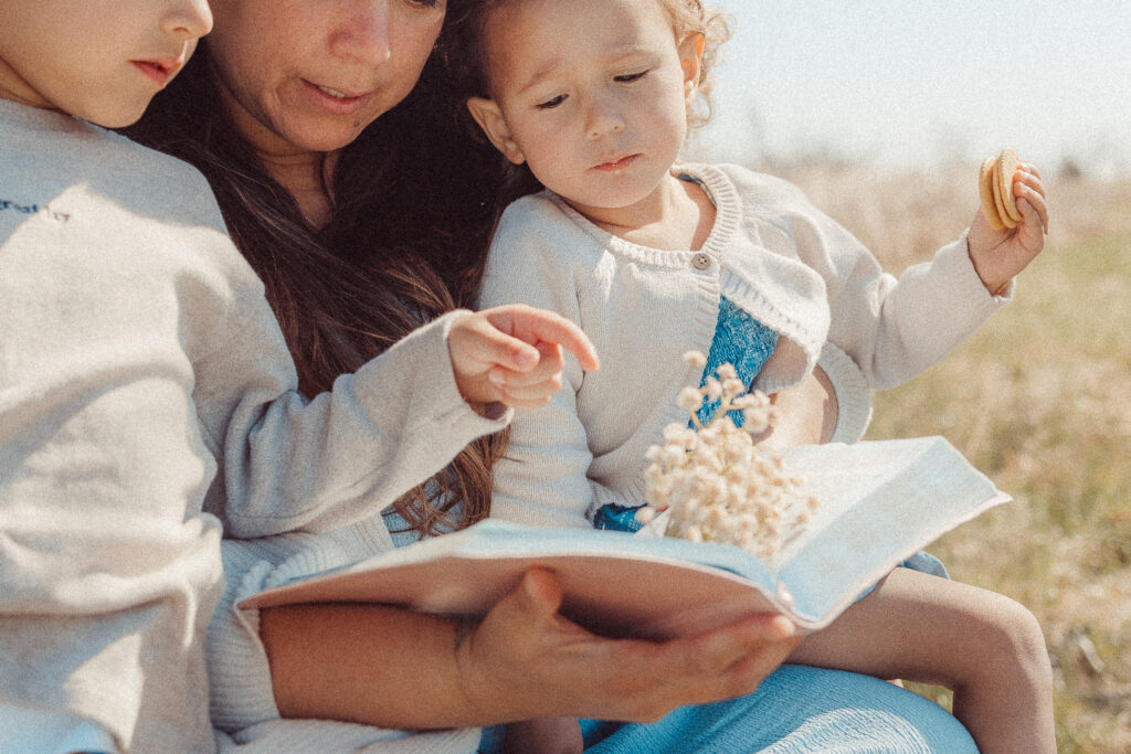 mother reads bible to her children during a mother's day mini session in Lawton, OK