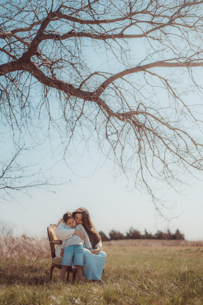 mother holds child under a tree during mother's day mini session in lawton, OK