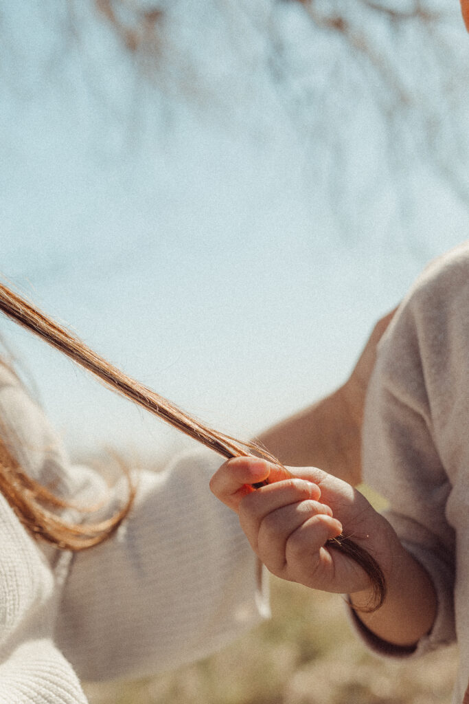 boy plays with mothers hair during mother's day mini session in Lawton, OK