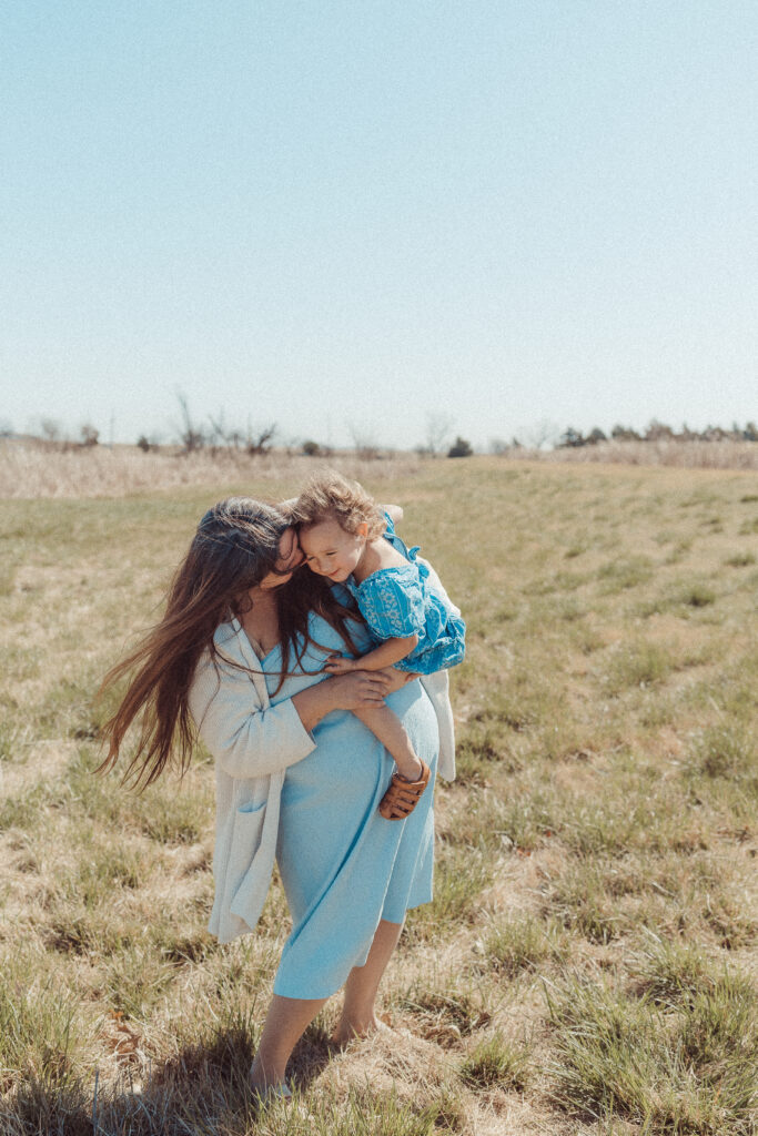 Mother plays with child in a field during mother's day mini session in Lawton, OK