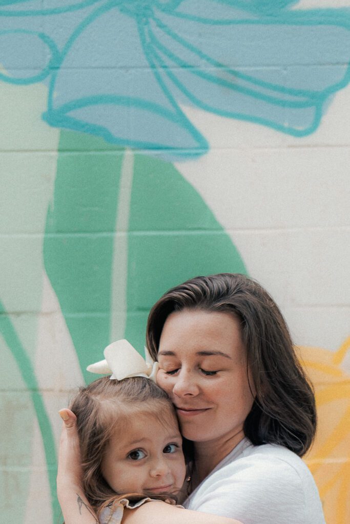 mother holds young daughter during mother's day mini session in lawton, ok